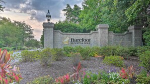 Eine Steinmauer mit dem Schriftzug "Barefoot Resort & Golf" und einem Lampenpfosten.