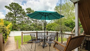 A wooden deck with a table and chairs, an umbrella, and a swing. - 2-bedroom villa minutes from Carytown, VCU, UofR, & Richmond Convention Center (Richmond)