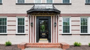 A traditional building with a black front door, brick steps, and a small brick porch. - 2-bedroom villa minutes from Carytown, VCU, UofR, & Richmond Convention Center (Richmond)
