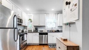 A modern kitchen with white cabinets, stainless steel appliances, and a wooden countertop. - 2-bedroom villa minutes from Carytown, VCU, UofR, & Richmond Convention Center (Richmond)