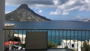 En balkong med utsikt över ett berg och havet.