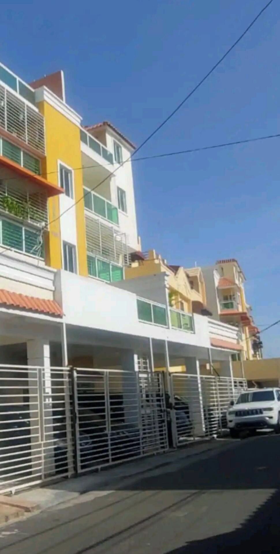 A multi-story residential building with balconies and a gated entrance.