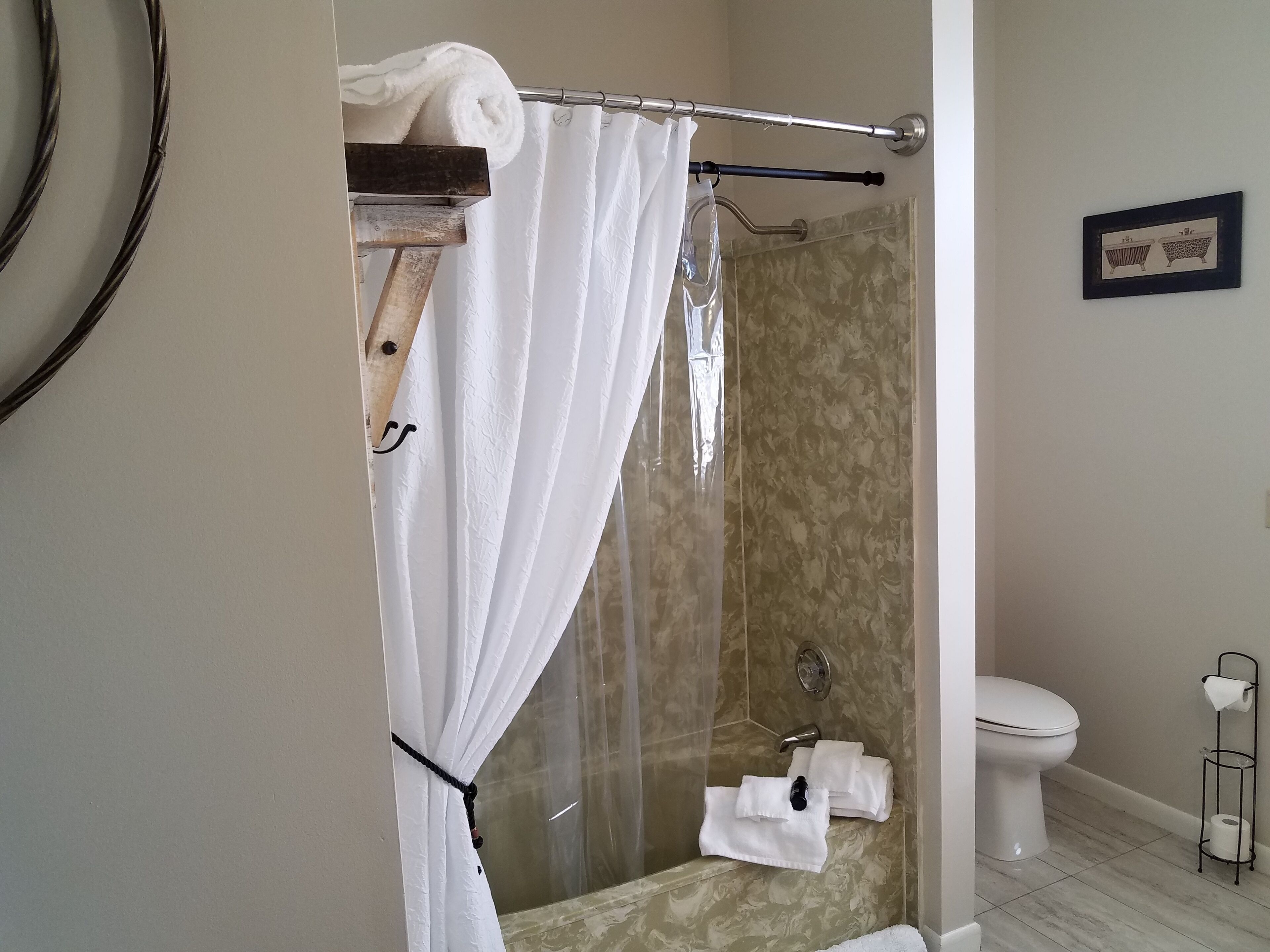 Une salle de bain avec une douche à parois de verre, des toilettes et un porte-serviettes.