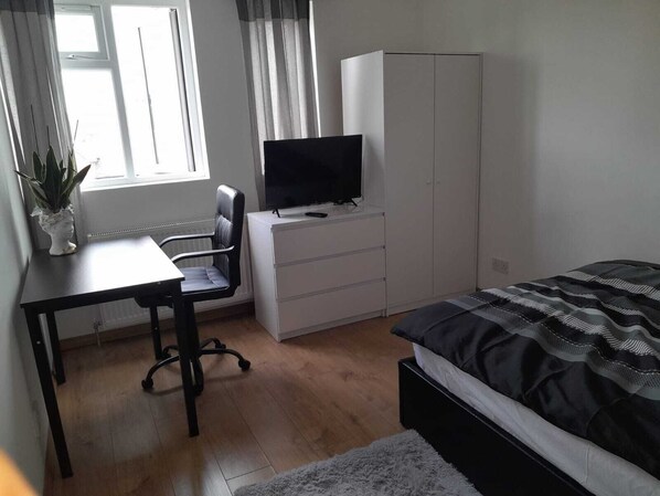 1 dormitorio, escritorio, tabla de planchar con plancha y ropa de cama