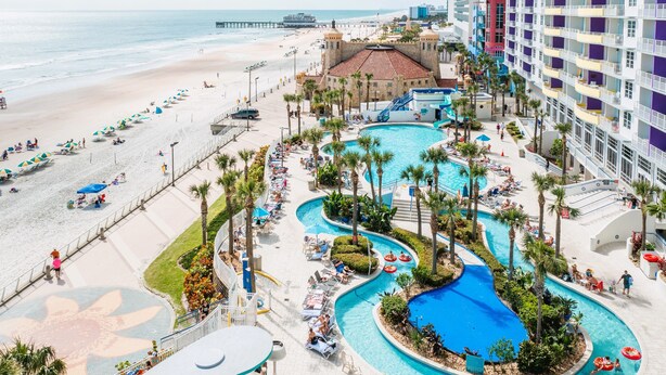A resort with a beach, a pool area, and a pier in the background. - Modern Beach Highrise  Ocean Walk Resort 1 BR Ocean View W/Jacuzzi Daytona Beach (Daytona Beach)