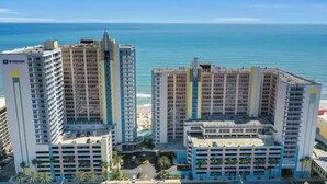 A high-rise hotel with multiple floors, a central courtyard, and a view of the ocean. - Modern Beach Highrise  Ocean Walk Resort 1 BR Ocean View W/Jacuzzi Daytona Beach (Daytona Beach)