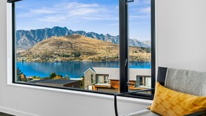 A room with a large window overlooking a lake and mountains. - 1 St. Marks (Queenstown)