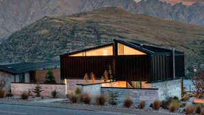 A modern house with a large glass window, surrounded by a mountainous landscape. - 1 St. Marks (Queenstown)