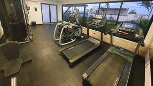 A gym with treadmills, a weight machine, and a rowing machine. - Syren 401 (Playa del Carmen)