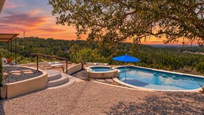 A swimming pool with a hot tub, lounge chairs, and a pergola with a view of the landscape. - 8 Private Acres | Pool, Hot Tub, Mini Golf (Dripping Springs)