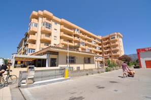 A multi-story hotel with balconies, a covered outdoor seating area, and a visible entrance. - Studio in Roses, Costa Brava! Ideal for 2 people, Near the Beach, Comfortable and Equipped. Book now! (Roses)