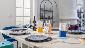 A dining area with a marble table set for four, blue chairs, and a white door in the background. - Appartement Armény - Welkeys (Marseille)