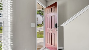A hallway with a pink door labeled "1740" leading to a residential area. - Sleeps 6 - 3 Queen Beds - 2 Mi Wake Forest + Hospital (Winston-Salem)
