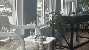 A room with a white chair, a table with a lamp, and a potted plant. - 3 bedroom house that sleeps 9 located in Oceanside Village, Surfside Beach (Surfside Beach)