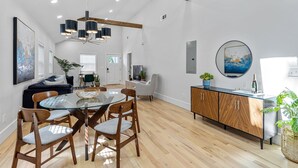Uma cozinha moderna com mesa de jantar de vidro, cadeiras de madeira e um armário de madeira.