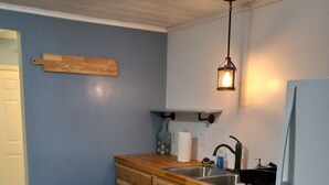 Una cocina con armarios de madera, un lavamanos, una estufa y un refrigerador.