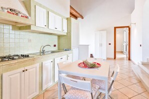 A kitchen with white cabinets, a gas stove, and a tiled backsplash.
