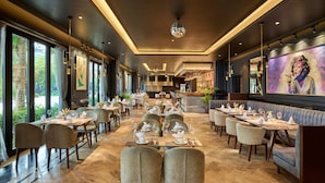 A spacious restaurant with multiple dining tables and chairs, large windows, and a modern ceiling design. - Ravatel Home Bac Giang (Bac Giang)