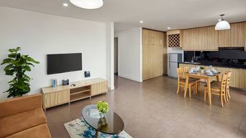 Una sala de estar moderna con un sofá, una mesa de centro con un jarrón, un televisor y un mueble de madera.