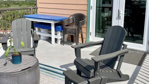 Une terrasse extérieure avec une table, des chaises et un pot de fleurs.