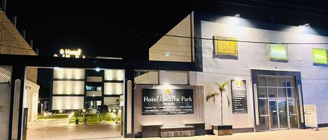 A hotel entrance with a sign for Hotel Buddha Park, including amenities like a conference hall and a spa.