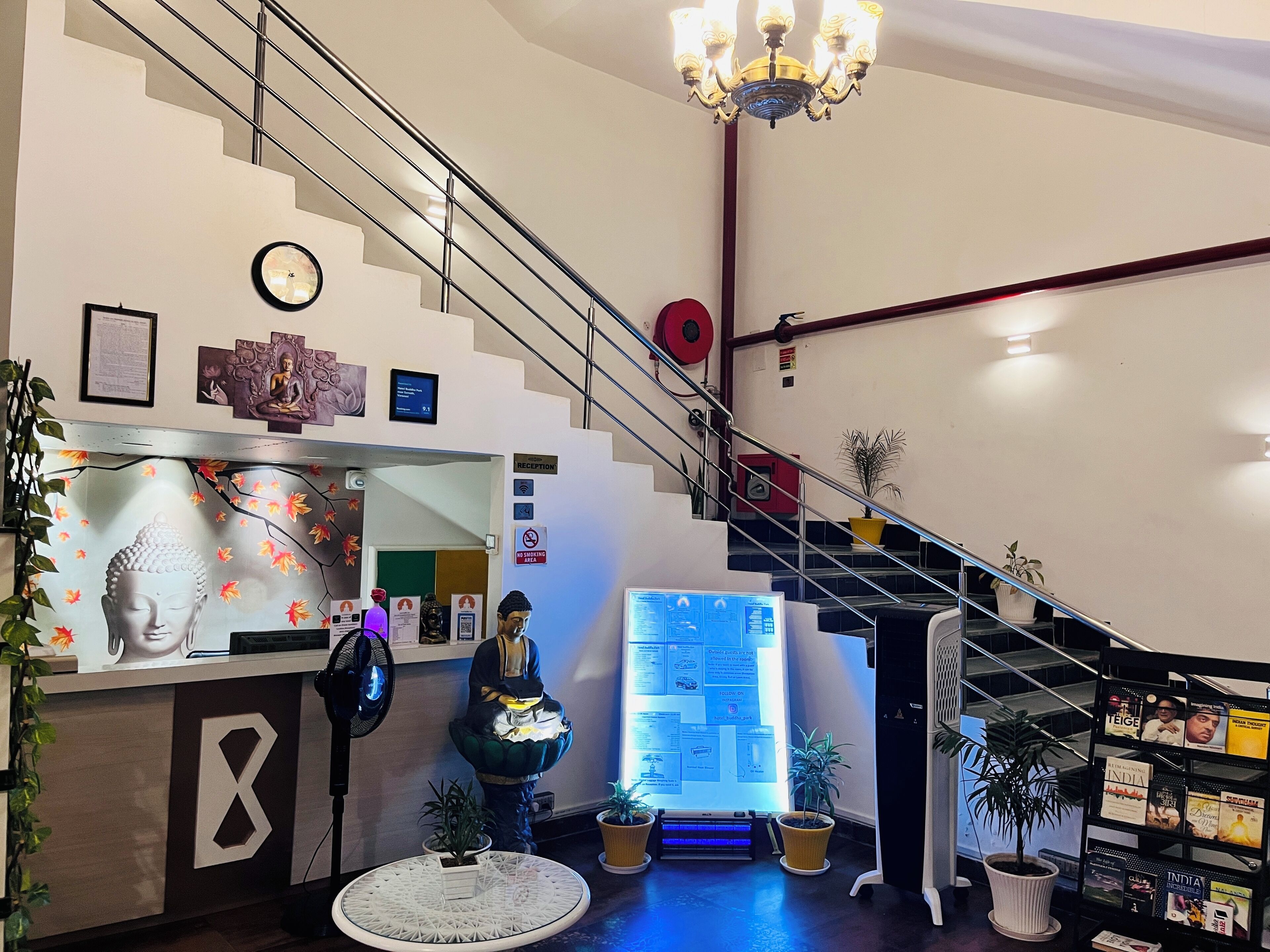 A reception area with a staircase, reception desk, and a digital display board.
