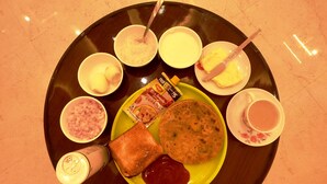 A breakfast tray with toast, jam, butter, and various condiments. - Hotel Buddha Park (Varanasi)