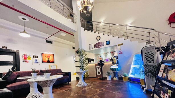 A modern lobby with a reception desk, seating area, and a staircase. - Hotel Buddha Park (Varanasi)