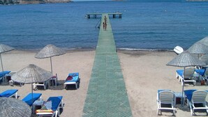 A beach with a pier extending into the sea, lounge chairs, and umbrellas. - Child-friendly holiday home with pool (Bagnols en Forêt)