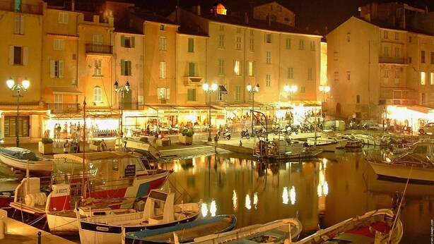 A marina at night with boats docked, buildings in the background, and a well-lit waterfront area. - Child-friendly holiday home with pool (Bagnols en Forêt)