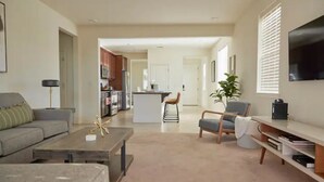A spacious living area with a sofa, coffee table, and a dining area with a kitchen in the background. - ★NEW★ Upscale House, Tahoe 30-min w/ Cal King (Reno)