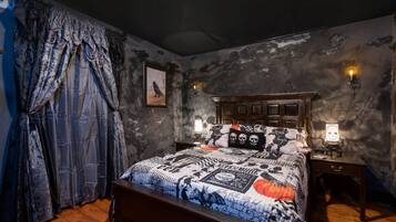 A bedroom with a large bed, a wooden headboard, and a nightstand with a lamp.