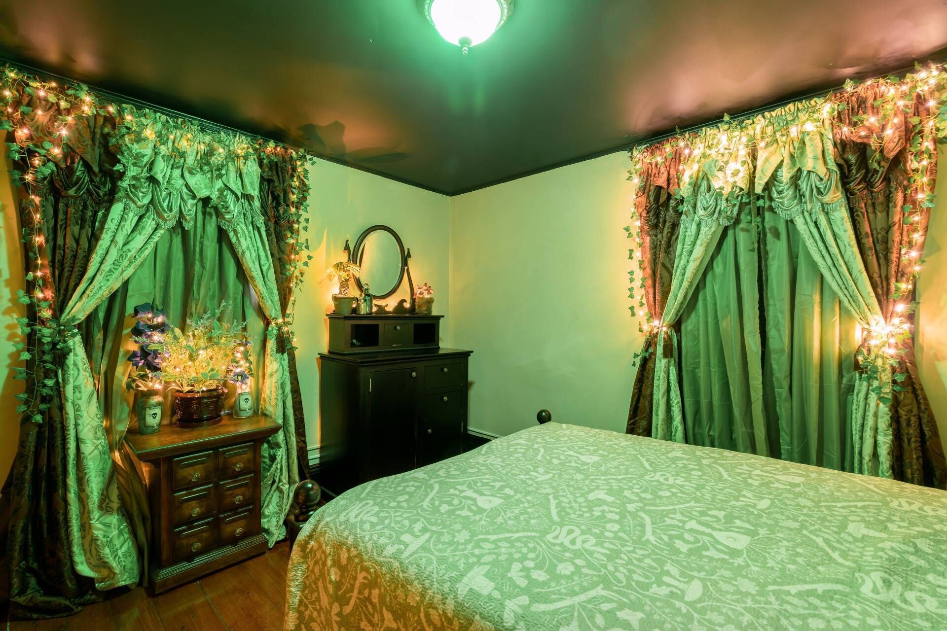 A bedroom with a bed, dresser, and mirror.