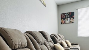Eine Reihe brauner Ledersofas, auf einem liegt eine Fernbedienung.