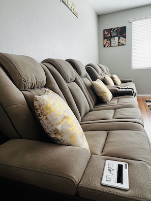 Relax in this stylish living room with a row of comfortable sofas and a unique decorative sign.