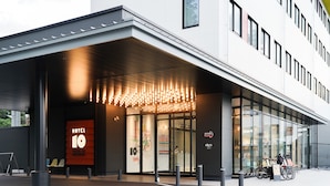 A modern hotel entrance with a prominent 'HOTEL 10' sign, glass doors, and a covered walkway. - SETOUCHI KEIRIN HOTEL 10 by Onko Chishin (Tamano)