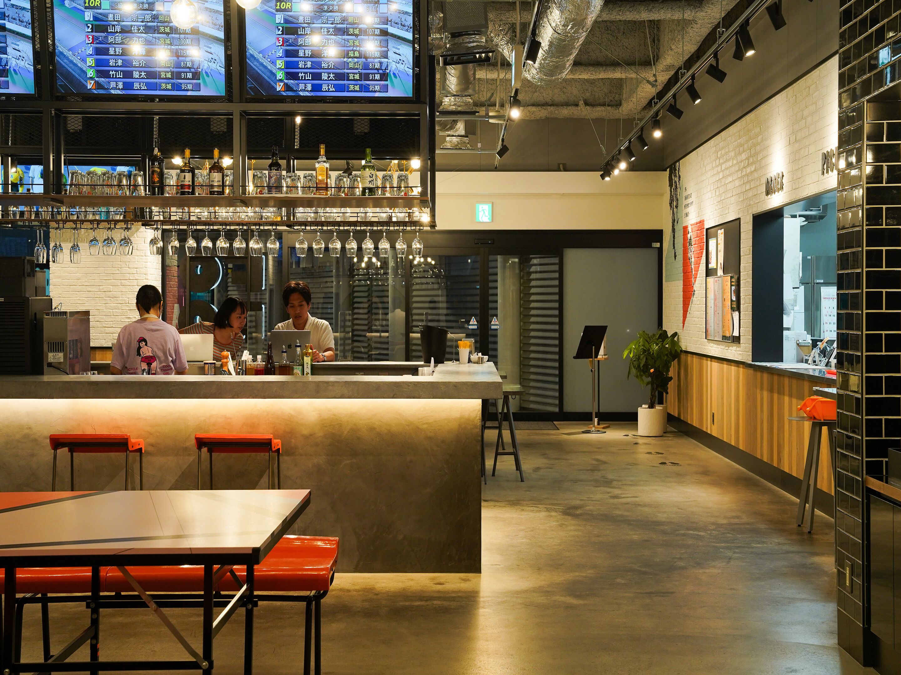 A modern bar area with a bar counter, stools, and a menu display.