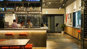 A modern bar area with a bar counter, stools, and a menu display.