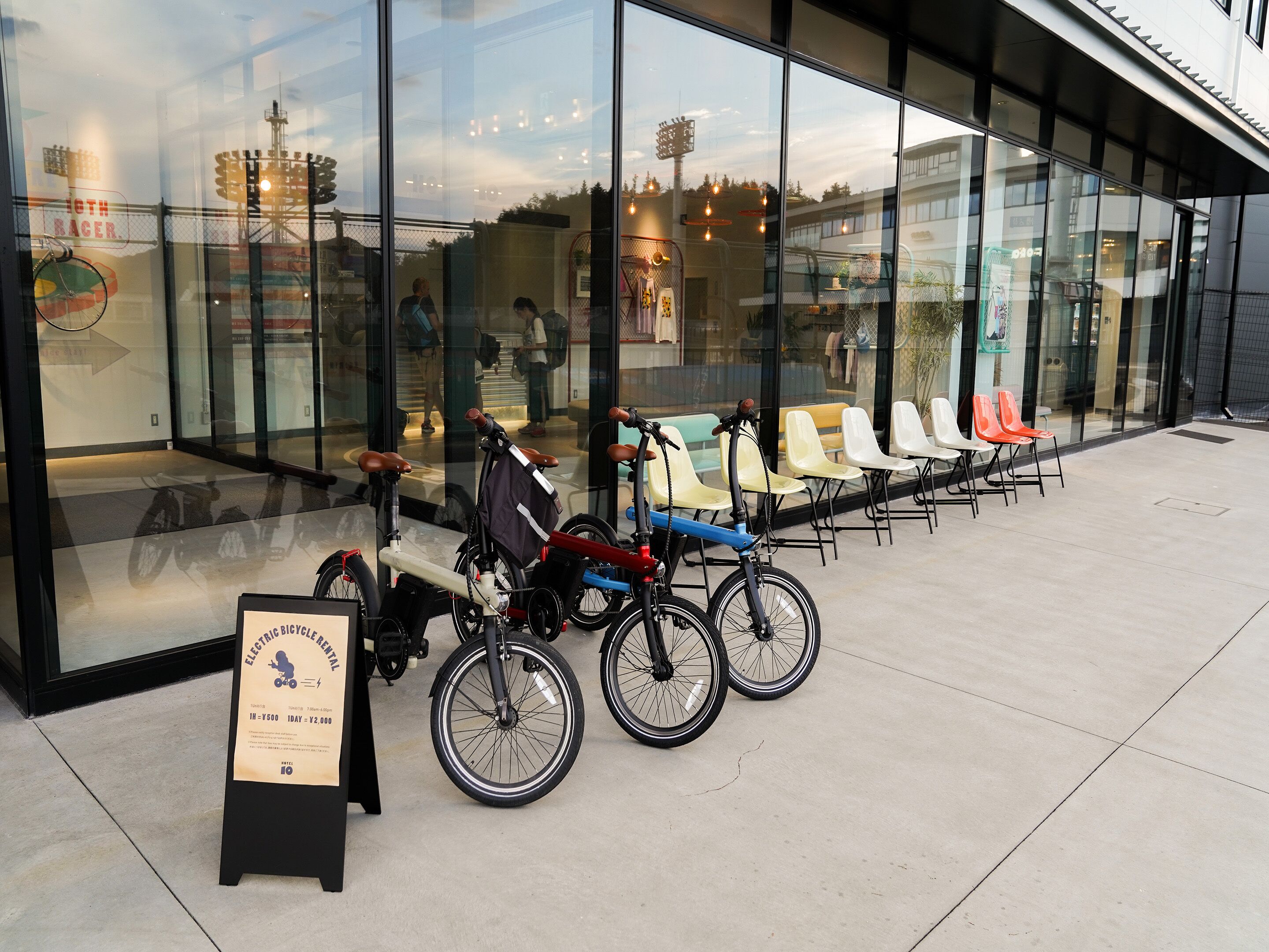 A glass-fronted building with bicycles parked outside.