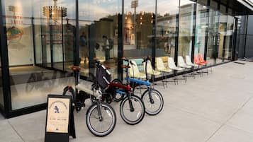 A glass-fronted building with bicycles parked outside.