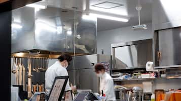 A modern kitchen with stainless steel appliances, a menu board, and a variety of cooking utensils.