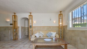 A cozy living room with a sofa, a coffee table, and bookshelves. - JUNAI, villa for 4 pax in Benissa with private swimming pool and free wifi (Benissa)