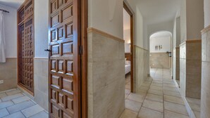 A hallway with a wooden door, tiled flooring, and a bed in the background. - JUNAI, villa for 4 pax in Benissa with private swimming pool and free wifi (Benissa)