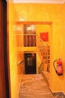 Una escalera con un extintor en la pared y una puerta al final.