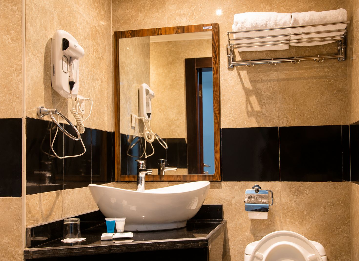A bathroom with a white sink, a mirror, a towel rack, and a toilet.