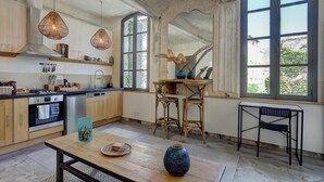 Une cuisine avec des armoires en bois, une cuisinière en acier inoxydable et une grande fenêtre.