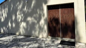 Un edificio con ingresso in pietra, una grande porta in legno e un tetto piastrellato.