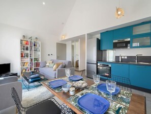 Un appartement moderne comprenant un coin repas, une cuisine et un salon.