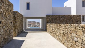 Un edificio moderno con un muro de piedra y una vista despejada de un paisaje montañoso.