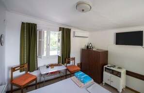 Cozy retreat with a single bed, nightstand, and flat-screen TV.